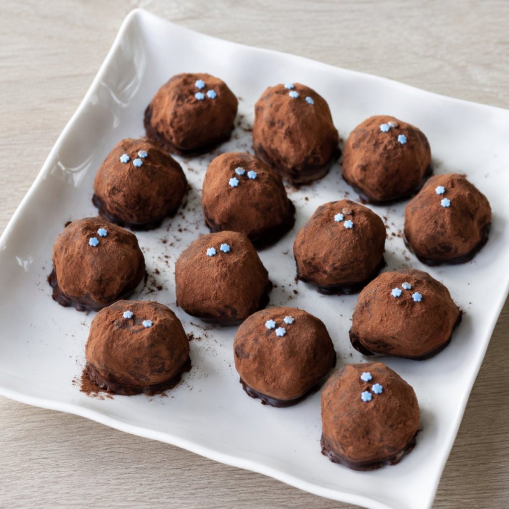 Slagroomtruffels met cacao en blauwe suikerbloemetjes, voor de geboorte van een jongen