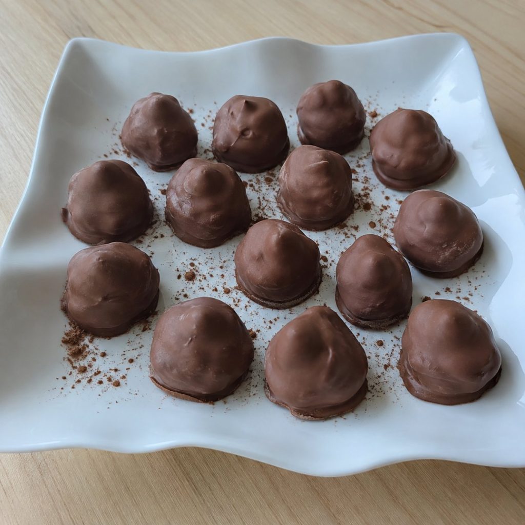 Handgemaakte hazelnoottruffels: een hele hazelnoot onder een laag Callebaut melkchocolade