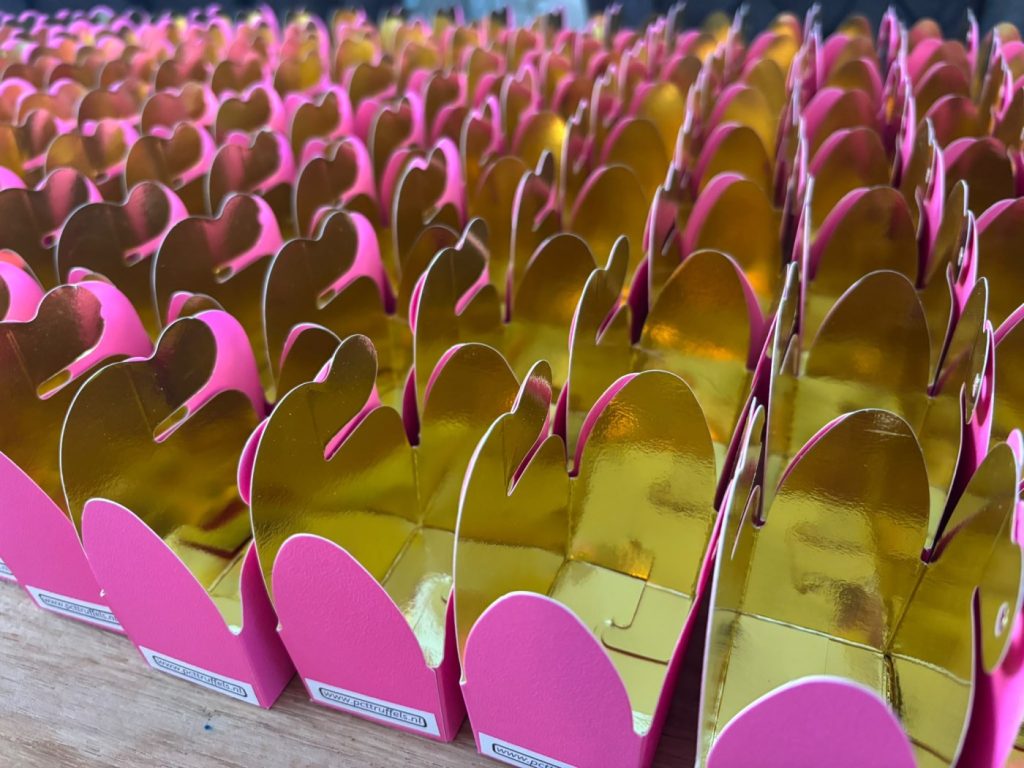 Rijen roze doosjes met gouden hartjes, klaar om gevuld te worden